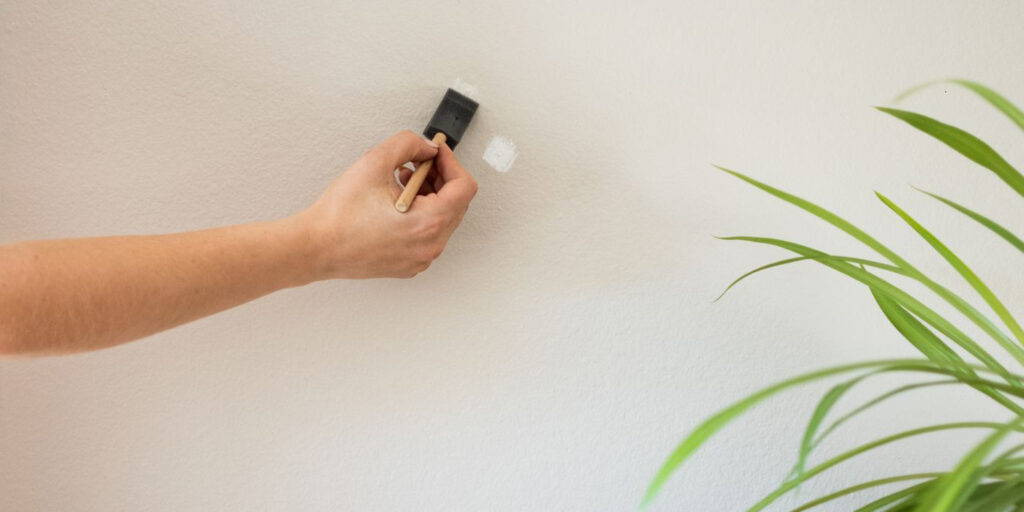 Small wall touch-up using a sponge brush on a light wall.